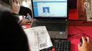 Petugas memasukan data seorang siswa saat membuat Kartu Identitas Anak (KIA) di SD Negeri 01 Sawah Baru, Ciputat, Jumat (27/4). KIA diberikan kepada anak-anak yang berusia dibawah 17 tahun. (Merdeka.com/Arie Basuki)