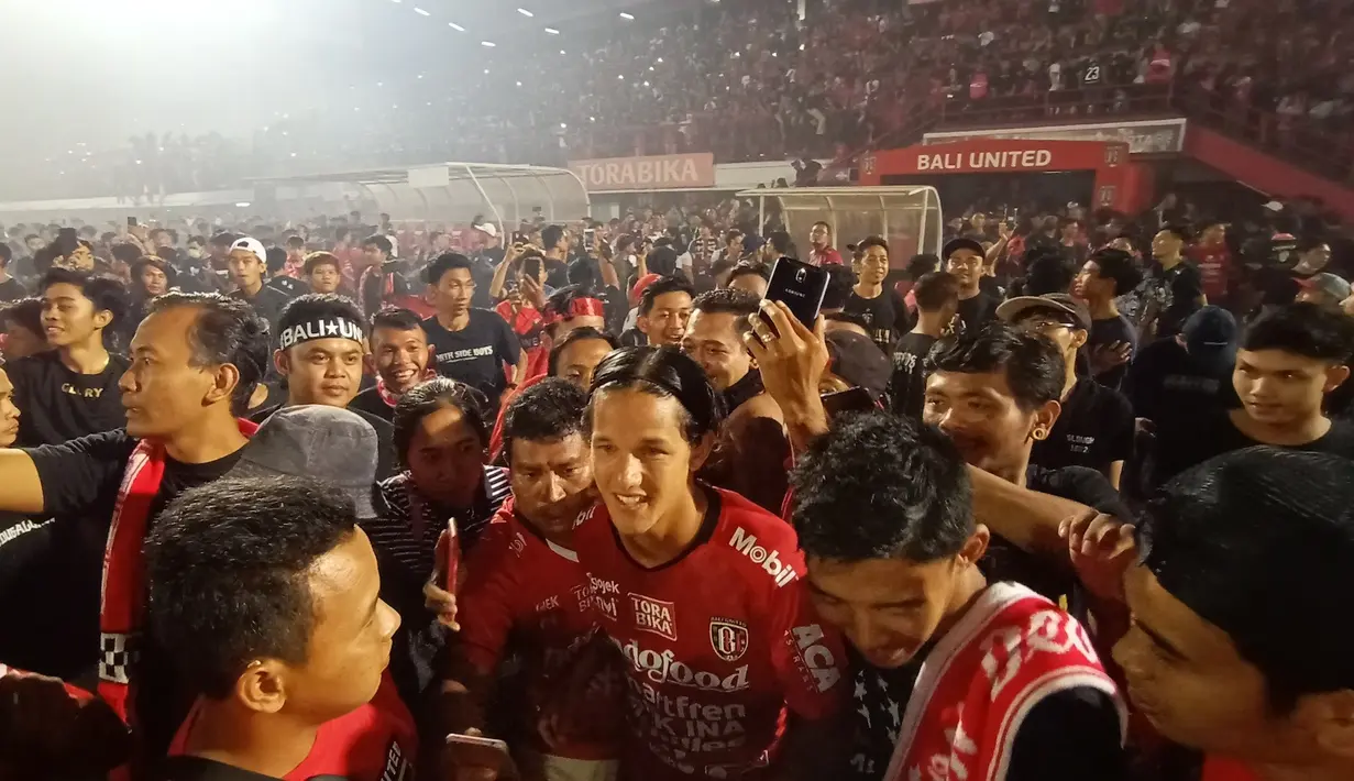 Gelandang Bali United, Irfan Bachdim, bersama para suporter saat merayakan gelar juara Liga 1 2019 di Stadion Kapten I Wayan Dipta, Bali, Minggu (22/12). Bali berada di peringkat satu dengan meraih 64 poin. (Bola.com/Aditya Wany)