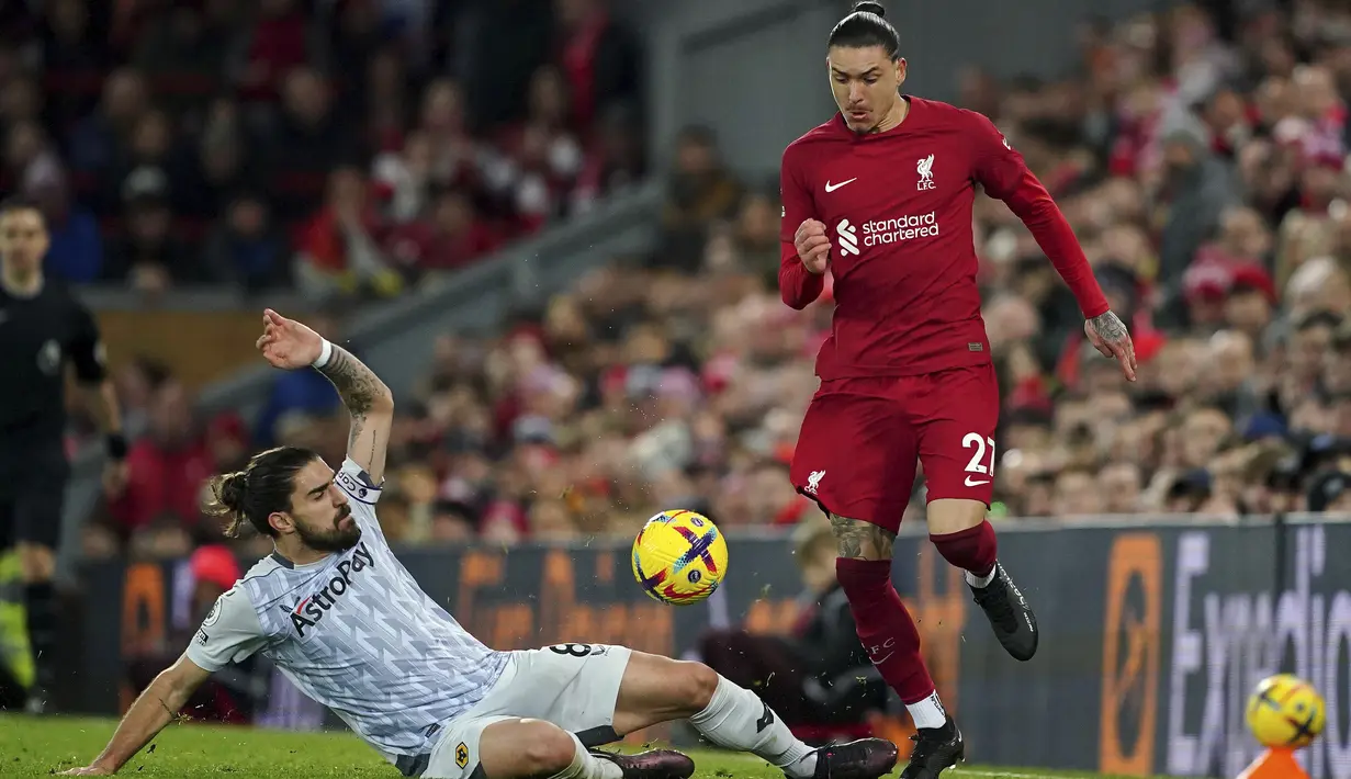 Penyerang Liverpool Darwin Nunez lolos dari gelandang Wolverhampton Wanderers Joao Moutinho  pada laga tunda Liga Inggris pekan ke-7 di Anfield, Rabu (2/3/2023) dini hari WIB. Liverpool sukses mencetak dua gol kemenangan melalui Virgil van Dijk (73') dan Mohamed Saah (77').  (Peter Byrne/PA via AP)