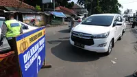 Petugas memeriksa kendaraan yang melintas di check point penyekatan arus mudik di kawasan Pasar Mudik, Bogor, Jumat (7/5/2021). Penyekatan pemudik pada jalur alternatif Parung diberlakukan jelang Lebaran guna mengantisipasi risiko peningkatan kasus COVID-19. (merdeka.com/Arie Basuki)