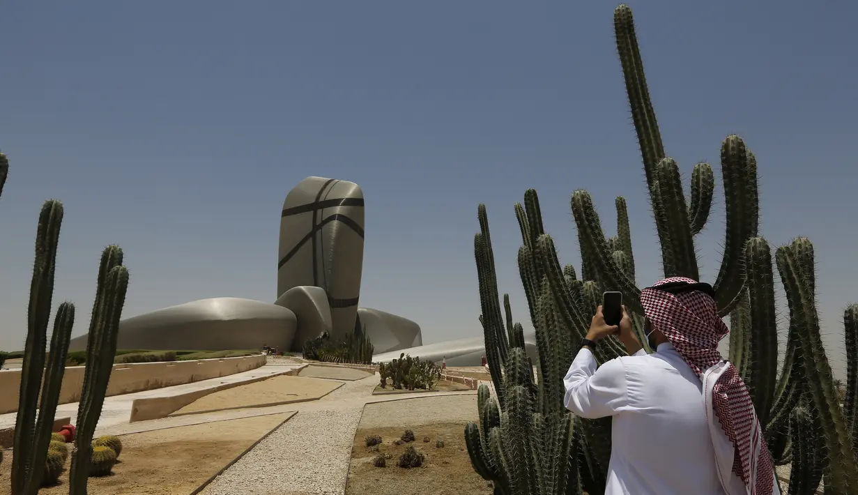 Seorang pria Saudi memfilmkan bagian luar King Abdulaziz Center for World Culture, juga dikenal sebagai Ithra, di Dammam, Arab Saudi, Minggu (27/6/2021).  Pusat tersebut dibangun oleh Saudi Aramco dan diresmikan oleh Raja Salman pada 2016. (AP Photo/Amr Nabil)