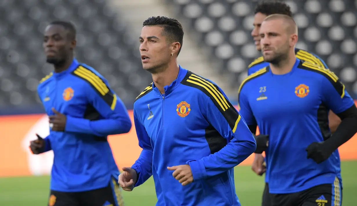 Penyerang Manchester United, Christiano Ronaldo (tengah) bersama rekan satu timnya melakukan pemanasan dalam sesi latihan di Bern (13/9/2021). Manchester United akan bertanding melawan Young Boys pada Grup F Liga Champions di Stadion Wankdorf. (AFP/Sebastien Bozon)