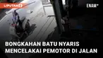 Seorang pemotor perempuan nyaris terkena bongkahan batu yang jatuh dari sebuah truk terekam CCTV