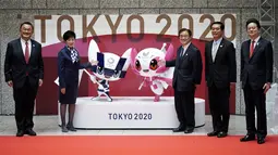 Penyelenggara berpose dengan Miraitowa dan Someity, maskot untuk Olimpiade dan Paralimpiade Tokyo 2020/2021, saat menandai 100 hari sebelum dimulainya Olimpiade di gedung Pemerintah Metropolitan Tokyo, Rabu (14/4/2021). Olimpiade Tokyo akan dibuka pada 23 Juli 2021. (AP Photo/Eugene Hoshiko, Pool)