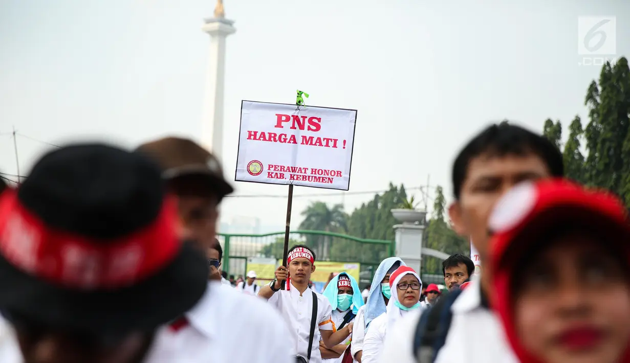 Seorang massa membawa poster dalam aksi damai di depan Istana Negara, Jakarta, Rabu (19/7). Mereka mendesak agar para pegawai non PNS yang telah mengabdi pada garda depan pelayanan publik, bisa diangkat menjadi PNS. (Liputan6.com/Faizal Fanani)