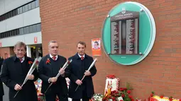 2.	Mantan pemain dan manajer Liverpool Kenny Dalglish (kiri), Chief Executive Ian Ayre (tengah) dan pelatih Liverpool, Brendan Rodgers, siap meletakkan bunga di depan dinding bertuliskan daftar korban Tragedi Hillsborough