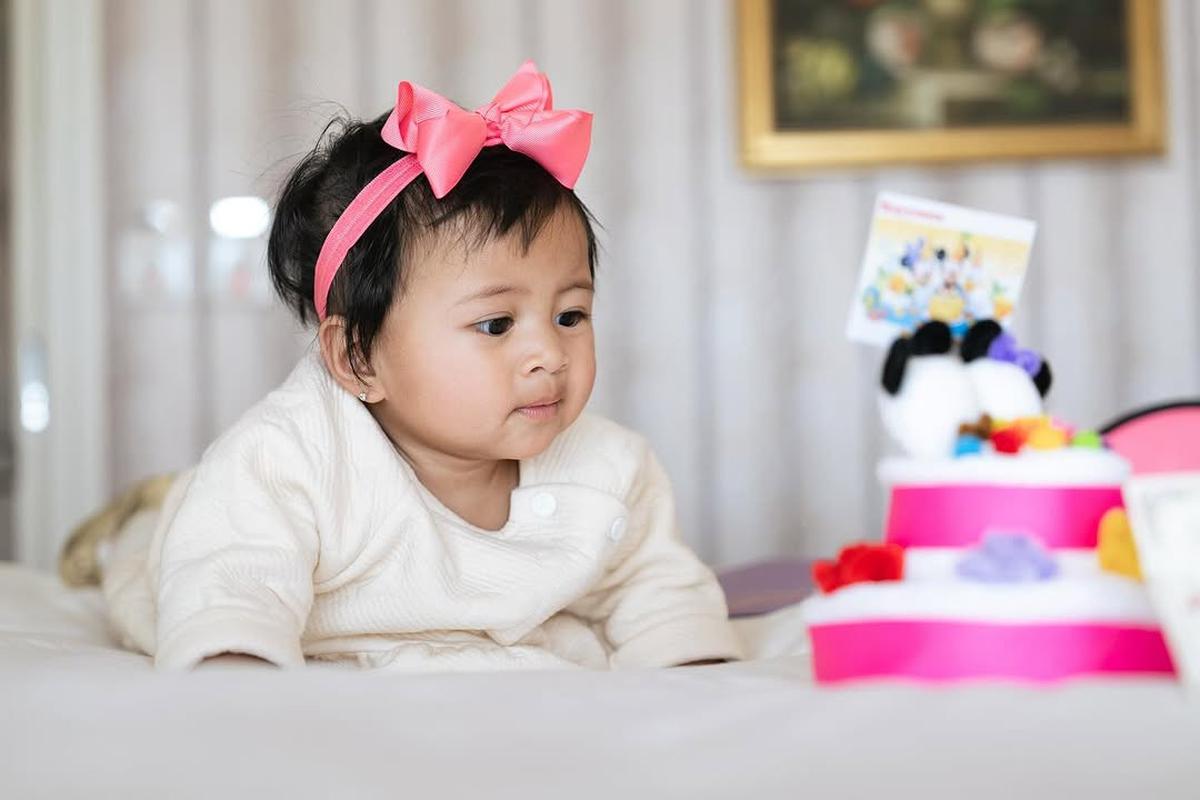 Potret Lily dengan Pita Pink di Kepala, Super Gemas Pose di Atas Kasur