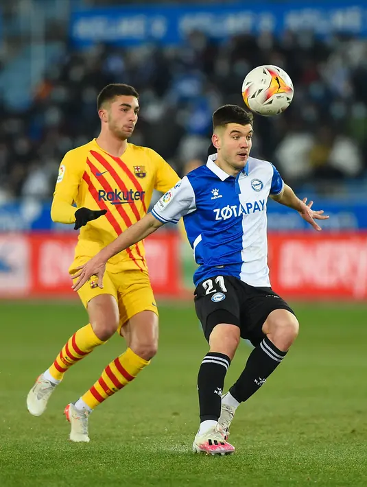 Pemain depan Barcelona Ferran Torres (kiri) bersaing dengan bek Deportivo Alaves Martin Aguirregabiria dalam duel pekan ke-22 La Liga 2021/22, di Estadio Mendizorroza, Senin (24/1/2022) dini hari WIB. Gol telat Frenkie De Jong memenangkan Barcelona 1-0. (Ander GILLENEA / AFP)