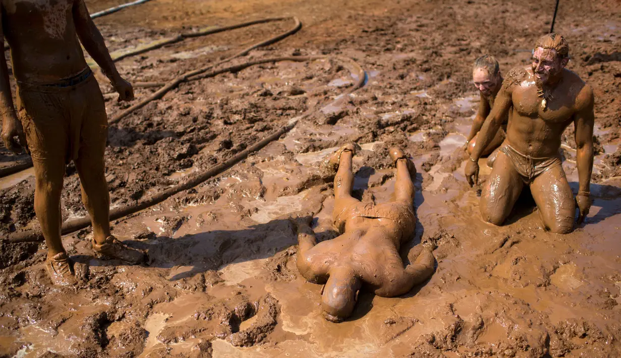 Sejumlah peserta bermandikan lumpur saat mengikuti Mud Day di Tel Aviv, Israel (24/3). Dalam acara ini para peserta harus melewati rintangan sepanjang 13 kilometer. (AP Photo/Oded Balilty)