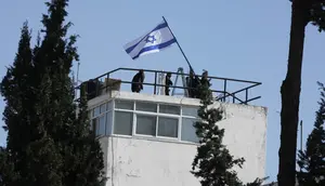 Foto-foto yang diperoleh Associated Press dan staf UNRWA pada Senin (8/12/2025) menunjukkan polisi mengibarkan bendera Israel dan memasuki area kompleks. (Dok. AP Photo/Mahmoud Illean)