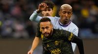 Pemain Paris Saint-Germain (PSG) Neymar berebut bola dengan pemain Riyadh All Star Talisca pada pertandingan sepak bola persahabatan di King Saud University Stadium, Riyadh, Arab Saudi, 19 Januari 2023. PSG mengalahkan Riyadh All Star dengan skor 5-4. (AP Photo/Hussein Malla)