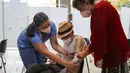 Seorang pria lansia didampingi istrinya (kanan) bersiap menerima suntikan BioNtech Pfizer COVID-19 sebagai booster di Santiago, Chile, 7 Februari 2022. Di tengah gelombang COVID-19, Chile memulai vaksinasi dosis keempat untuk warga di atas usia 55 tahun. (JAVIER TORRES/AFP)