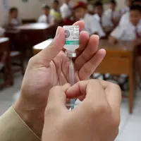 Seorang paramedis menyiapkan vaksin difteri untuk diberikan kepada siswa di sebuah sekolah dasar pada hari pertama sebuah kampanye di Tangerang, Senin (11/12). (AP Photo / Tatan Syuflana)