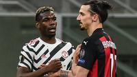 Paul Pogba bersama Zlatan Ibrahimovic usai Manchester United kalahkan AC Milan, 1-0 di leg 2 babak 16 besar Liga Europa 2020/2021, Jumat (19/03/2021) dini hari WIB. (Marco BERTORELLO / AFP)