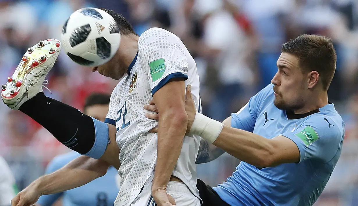Pemain Uruguay, Sebastian Coates (kanan) menghalau bola dari sundulan pemain Rusia, Artyom Dzyuba pada laga grup A Piala Dunia 2018 di Samara Arena, Samara, Rusia, (25/6/2018). Uruguay menang 3-0. (AP/Hassan Ammar)