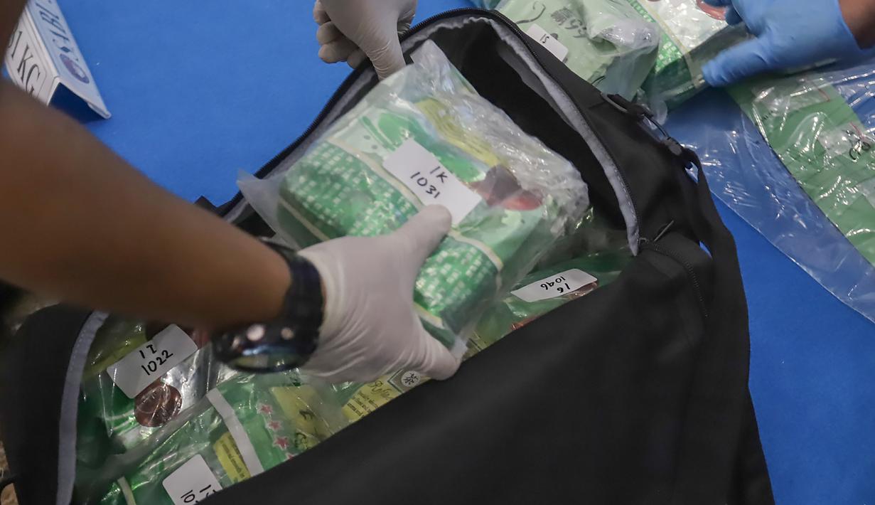 Nilai barang bukti tersebut ditaksir mencapai lebih dari Rp 60,5 miliar dan disebut berpotensi menyelamatkan 162.202 jiwa dari penyalahgunaan narkoba. Tampak dalam foto, personel Dirtpidnarkoba Bareskrim Polri memperlihatkan barang bukti pengungkapan peredaran narkoba jelang gelaran Djakarta Warehouse Project (DWP) 2025 di Bali pada 12–14 Desember 2025 lalu di gedung Bareskrim Mabes Polri, Jakarta, Senin (22/12/2025). (merdeka.com/Arie Basuki)