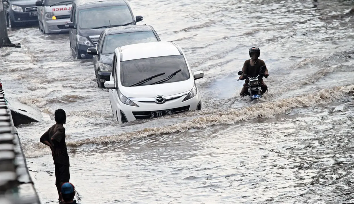 Beberapa kendaraan nekat menerobos banjir di Jl.Pemuda, Taman Ria Senayan demi mencapai tujuannya, Jakarta, Jumat (30/5/2014) (Liputan6.com/Faizal Fanani)