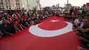 Bendera nasional Turki berukuran besar dibentangkan pendukung Presiden Turki, Tayyip Erdogan di Taksim Square, pusat kota Istanbul, Sabtu (16/7). Ratusan warga turun ke jalan untuk merayakan kegagalan kudeta militer di Turki. (REUTERS/Huseyin Aldemir)