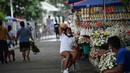 Penjual bunga menunggu pelanggan di dekat pemakaman di Manila, Filipina (28/10/2021). Pemerintah setempat akan menutup pemakaman nasional untuk Hari Semua Orang Kudus karena pandemi virus corona Covid-19. (AFP/Ted Aljibe)