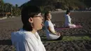 Turis berlatih yoga di pantai di Adrasan, barat Antalya, Turki (24/9/2021). Orang-orang menikmati cuaca hangat di wilayah Mediterania saat salju pertama menyelimuti pegunungan tinggi di timur laut Turki. (AP Photo/Burhan Ozbilici)