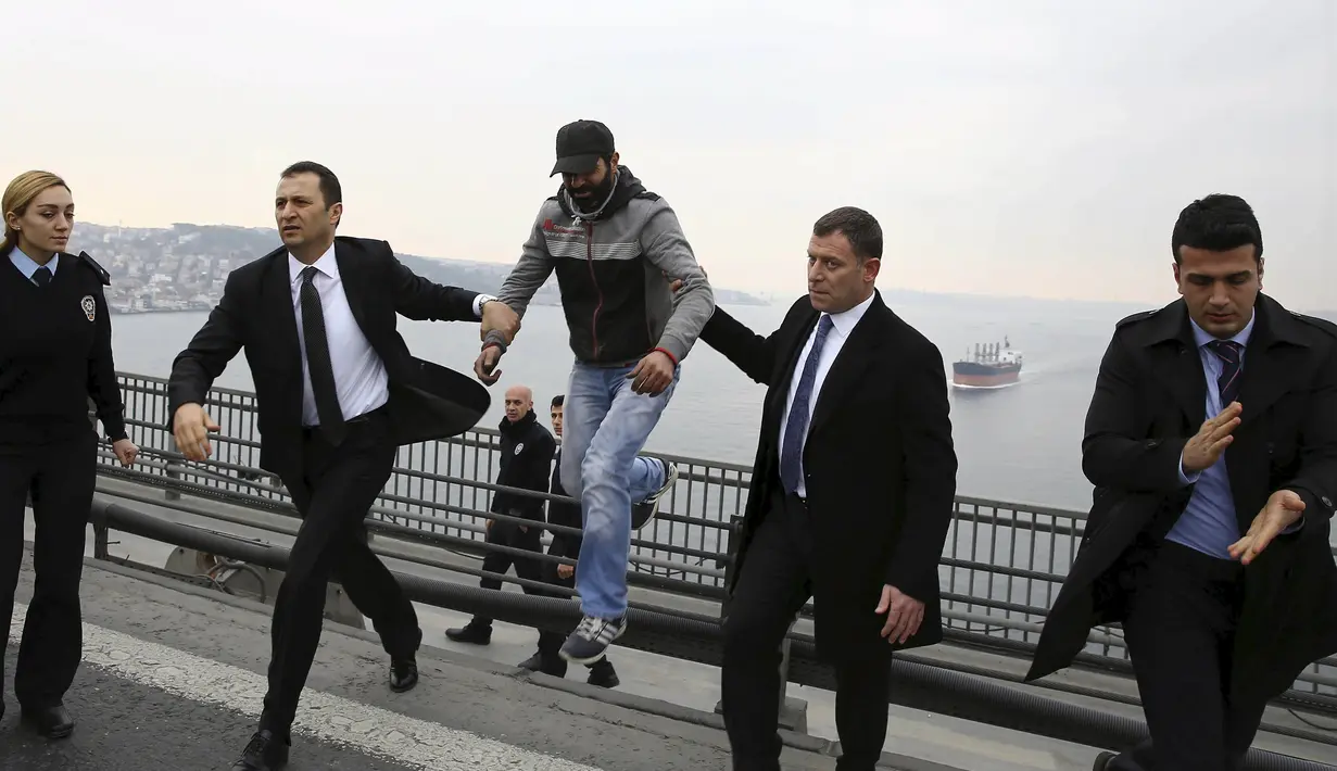 Pasukan pengamanan presiden menggiring seorang pria bernama Vezir Catras, yang hendak melompat dari jembatan Bosphorus saat iring-iringan Presiden Tayyip Erdogan melintas di Istanbul, Turki, (26/12/2015). (Reuters)