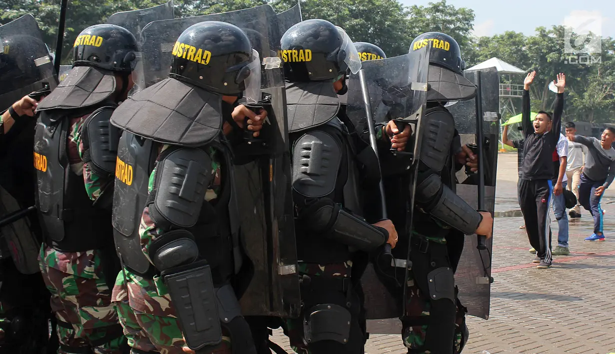 Petugas gabungan berlindung saat bentrok dengan pengunjuk rasa dalam simulasi pengamanan Pemilu 2019 di kawasan ICE BSD, Tangsel, Banten, Jumat (8/2). Kegiatan ini melibatkan unsur TNI AD, Polres Tangsel, Pemda Tangsel dan KPU. (Merdeka.com/Arie Basuki)