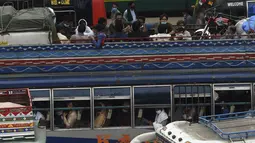 Warga berada di bus saat mereka melakukan perjalanan ke kampung halaman mereka menjelang perayaan Idul Fitri di Lahore (7/5/2021). Lebaran Idul Fitri jatuh pada 13 Mei 2021. (AFP Photo/Arif Ali)