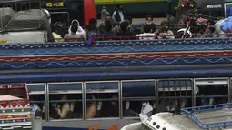 Warga berada di bus saat mereka melakukan perjalanan ke kampung halaman mereka menjelang perayaan Idul Fitri di Lahore (7/5/2021). Lebaran Idul Fitri jatuh pada 13 Mei 2021. (AFP Photo/Arif Ali)