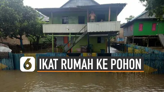 Banjir di Desa Bondra, Kabupaten Polewali Mandar, Sulawesi Barat meninggi. Warga mengikat rumah mereka dengan pohon agar tak terseret banjir.