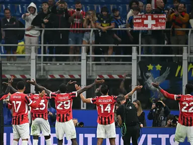 Para pemain AC Milan menyapa para penggemar usai memenangi laga Serie A Italia melawan Inter Milan di stadion Giuseppe Meazza, Milan, pada Minggu 22 September 2024 atau Senin (23/9/2024) dini hari WIB. (Gabriel BOUYS/AFP)