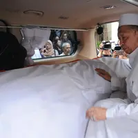 Wakil Presiden ke-9 RI, Hamzah Haz memegang peti jenazah istrinya, Asmaniah jelang diberangkatkan dari rumah duka di Jakarta, Selasa (12/9). Jenazah akan dimakamkan di pemakaman keluarga di Bogor, Jawa Barat. (Liputan6.com/Helmi Fithriansyah)