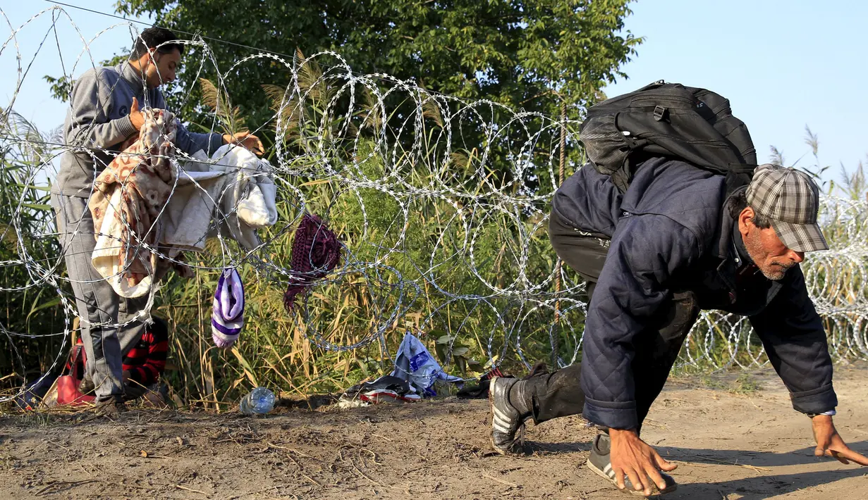 Sejumlah imigran Suriah berlari usai berhasil melewati pagar berduri di wilayah Hungaria dekat perbatasan Serbia, Roszke, Kamis (27/8/2015). Hungaria berencana untuk memperketat perbatasan bagian selatannya dari para pengungsi. (REUTERS/Bernadett Szabo)
