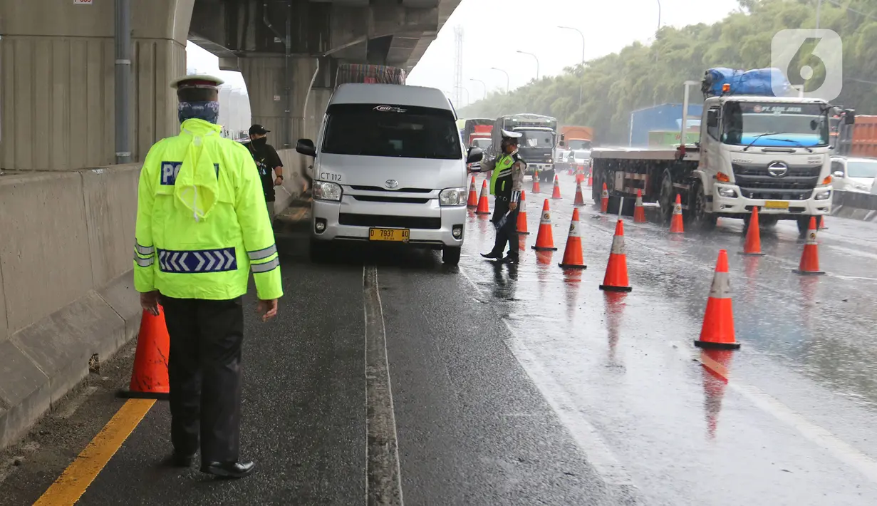 Petugas kepolisian memeriksa kendaraan yang melintasi Pos Penyekatan Jalur Mudik di Gerbang Tol Cikarang Barat, Kabupaten Bekasi, Senin (18/5). Memasuki H-6 Lebaran, puluhan kendaraan diminta untuk putar balik karena melanggar larangan mudik yang ditetapkan pemerintah. (Liputan6.com/Herman Zakharia)