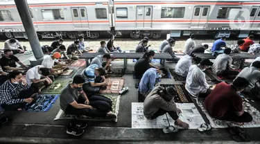 Kereta commuter line melintas dekat jemaah yang tengah salat Jumat di Stasiun Kampung Bandan, Jakarta, Jumat (7/5/2021). Jemaah Masjid Al-Hidayah salat Jumat di Stasiun Kampung Bandan karena keterbatasan lahan, terlebih jumlah meningkat di saat Ramadan. (merdeka.com/Iqbal S. Nugroho)