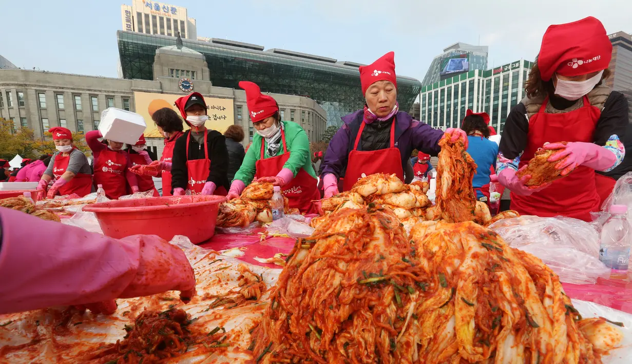 Peserta membuat kimchi, hidangan tradisional Korea Selatan, selama Festival Kimchi tahunan di pusat kota Seoul, Jumat (3/11). Sekitar 4.700 peserta diharapkan mampu menghasilkan 120 ton kimchi. (AP Photo/Ahn Young-joon)