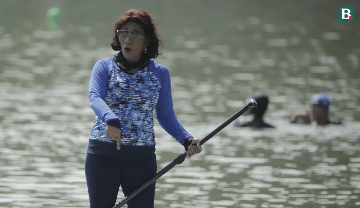 Menteri Kelautan dan Perikanan, Susi Pudjiastuti, menyapa penonton saat bermain paddle board di Danau Sunter, Jakarta, Minggu (25/2/2018). Kegiatan ini dilakukan dalam rangka Festival Danau Sunter. (Bola.com/Okie Prabhowo)