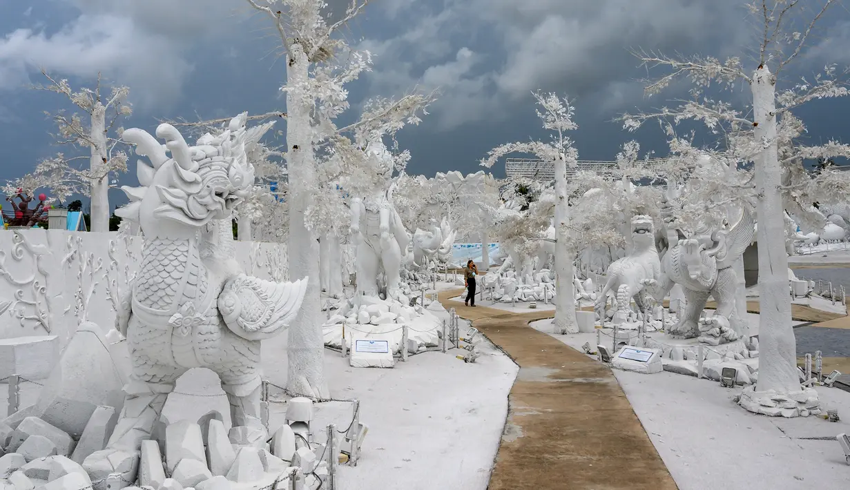 Foto pada yang diabadikan 2 September 2020 menunjukkan seorang pekerja berjalan di antara patung-patung mitologi yang terbuat dari pasir putih menyerupai es di taman "Frost Magical Ice of Siam", di luar Pattaya, Thailand. (Photo by Mladen ANTONOV / AFP)