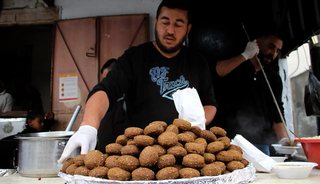 Para pekerja Palestina menyiapkan makanan gratis pada hari keempat Ramadan di Deir al-Balah, Jalur Gaza tengah, pada 27 April 2020 Warga Palestina merayakan Ramadan, bulan suci umat Islam, di tengah situasi ekonomi yang memburuk akibat pandemi COVID-19. (Xinhua/Rizek Abdeljawad)