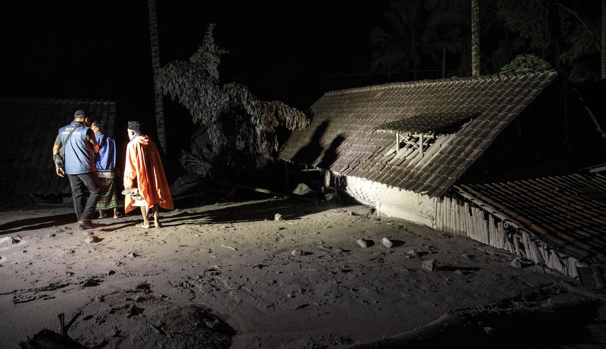 Warga dan tim penyelamat memeriksa area yang tertutup abu vulkanik dalam upaya mencari korban atau jenazah pasca erupsi Gunung Semeru di Desa Sumber Wuluh, Lumajang, Minggu (5/12/2021). (AFP/Juni Kriswanto)