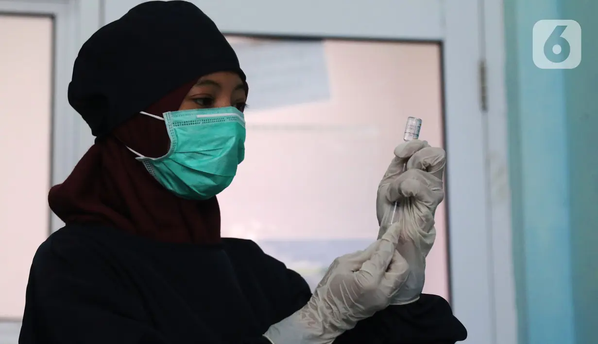 Vaksinator menyiapkan vaksin COVID-19 sebelum disuntikkan ke tenaga kesehatan yang bertugas di Puskesmas Jurang Mangu, Tangerang Selatan, Jumat (15/1/2021). Program vaksinasi COVID-19 tahap pertama kepada tenaga kesehatan mulai dilakukan di berbagai daerah di Indonesia. (Liputan6.com/Angga Yuniar)