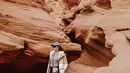 Berpose di depan batu pasir di Antelope Canyon, Lake Powell Page Arizona, Nikita Willy tampil stylish dengan padu padan t-shirt, puff jacket, dan pants. Aksesori berupa topi pun melengkapi penampilannya. (Instagram/nikitawillyofficial94).