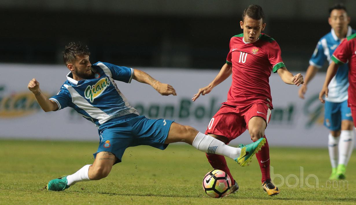 Pemain Timnas Indonesia U-19, Egy Maulana (kanan) mencoba melewati pemain Espanyol B pada laga persahabatan di Stadion GBLA, Bandung, (15/7/2017). Timnas U-19 kalah 2-4. (Bola.com/Nicklas Hanoatubun)
