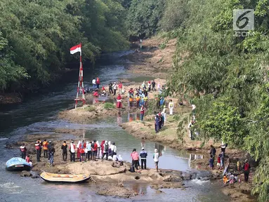 Komunitas Ciliwung Depok mengikuti upacara bendera di Sungai Ciliwung, Jawa Barat, Jumat (17/8). Upacara di tengah aliran Sungai Ciliwung tersebut dalam rangka memperingati HUT ke-73 Republik Indonesia. (Liputan6.com/Immanuel Antonius)