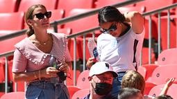Annie Kilner, tunangan pemain Inggris Kyle Walker (kanan) merapikan rambutnya saat berbincang Coleen Rooney, istri mantan pemain Inggris Wayne Rooney selama pertandingan grup D antara Inggris melawan Kroasia di stadion Wembley di London, Minggu (13/6/2021). (AFP/Pool/Glyn Kirk)