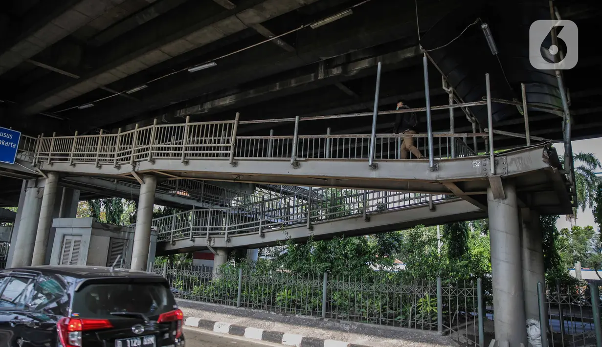 Pejalan kaki melintas di jembatan penyeberangan orang (JPO) halte transjakarta Bea Cukai di Jalan Ahmad Yani, Jatinegara, Jakarta, Kamis (5/12/2019). Sementara ini JPO hanya dipasang besi seadanya sebagai pengaman untuk para pengguna yang melintasi jembatan tersebut. (Liputan6.com/Faizal Fanani)