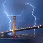 Kilatan petir terlihat di atas jembatan Golden Gate di San Francisco, California, AS (11/9). Petir merupakan Gejala alam yang biasanya muncul pada musim hujan di saat langit memunculkan kilatan cahaya sesaat yang menyilaukan. (AFP Photo/Josh Edelson)