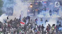Petugas Brimob Polri menembakkan gas air mata untuk membubarkan massa usai terjadi lemparan batu di Jalan MH Thamrin, Jakarta, Selas (13/10/2020). Massa pengunjuk rasa yang menolak Omnibus Law akhirnya dibubarkan aparat. (merdeka.com/Arie Basuki)