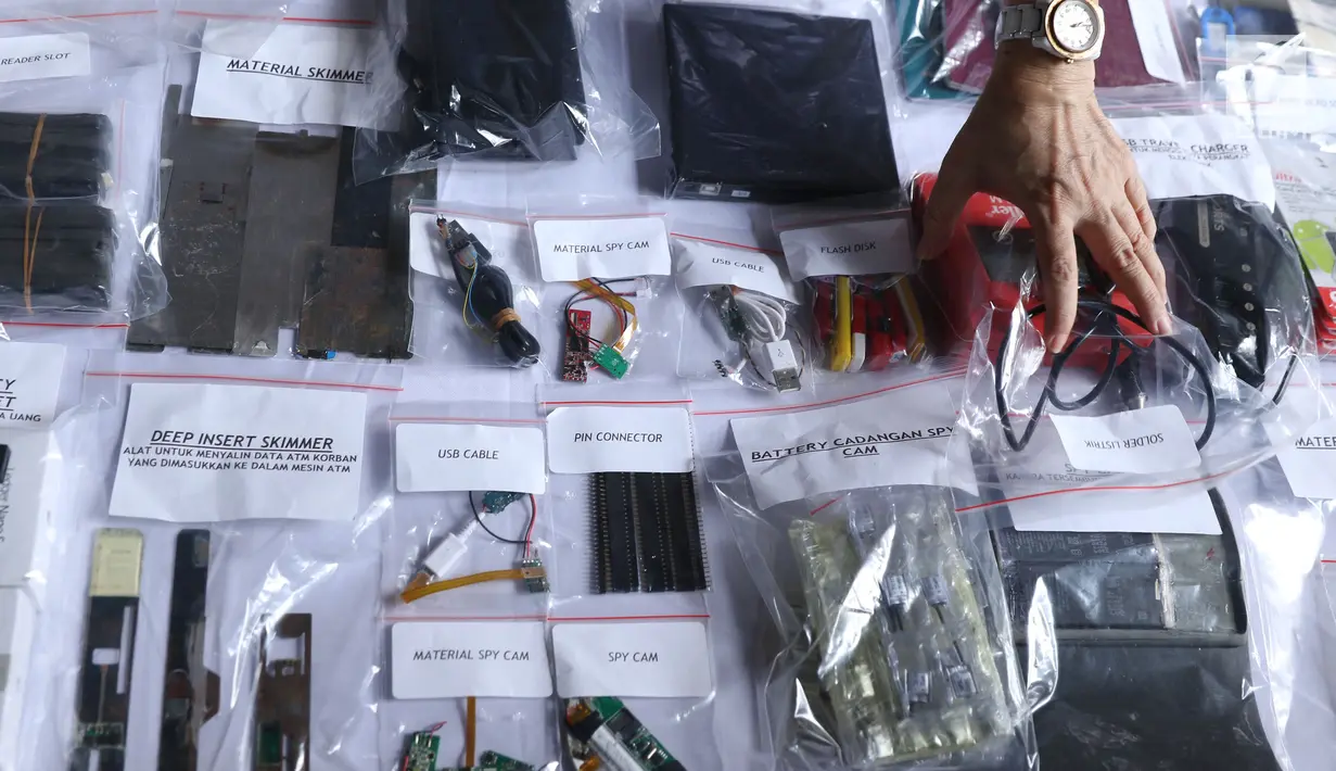 Petugas menunjukkan barang bukti pembobol uang dengan teknik skimming diperlihatkan petugas Resmob Polda Metro Jaya saat rilis di Jakarta, Sabtu (17/3). Sindikat ini membobol 64 bank pada sejumlah negara. (Liputan6.com/Helmi Fithriansyah)