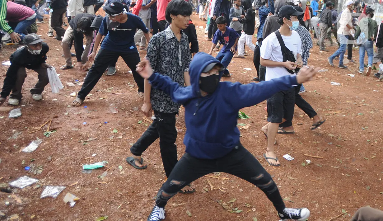 Sejumlah pengunjuk rasa melemparkan batu di Jalan MH Thamrin, Jakarta, Selas (13/10/2020). Massa pengunjuk rasa yang menolak Omnibus Law akhirnya dibubarkan dengan tembakan gas air mata. (merdeka.com/Arie Basuki)