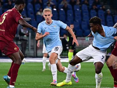 Gelandang Lazio, Fisayo Dele-Bashiru (kedua kanan) berebut bola dengan Gianluca Mancini (AS Roma) saat laga pekan ke-32 Serie A Italia musim 2024/2025 di Stadion Olimpico, Roma, 13 April 2025 atau Senin (14/4/2025) dini hari WIB. (Tiziana FABI/AFP)